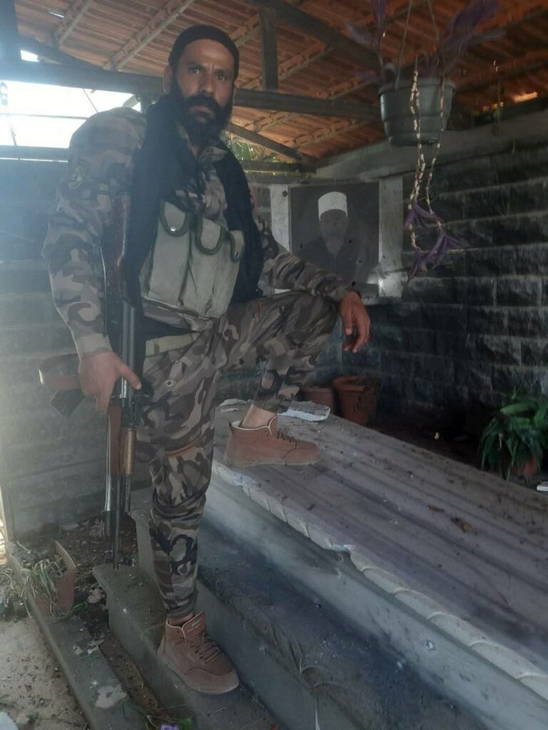 Hikmet el-Hicri ile bağlantılı olduğu bildirilen bir militan, Onur Adamları Hareketi’nin kurucusu ve Leys el-Belus’un babası Vahid el-Belus’un mezarına girerek saygısızlık etmiştir. (Qalaat Al Mudiq/Sosyal Medya)